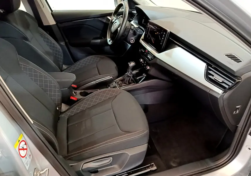 Intérieur avant droit du Skoda Kamiq gris clair 2022, sièges noirs avec surpiqûres et tableau de bord moderne.
