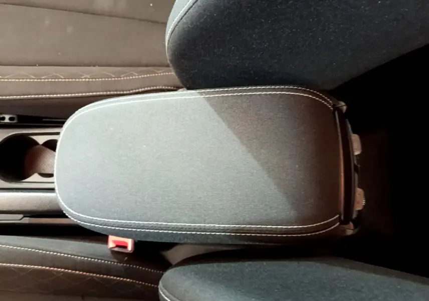 Accoudoir central noir avec surpiqûres blanches dans l'habitacle du Skoda Kamiq gris clair 2022.