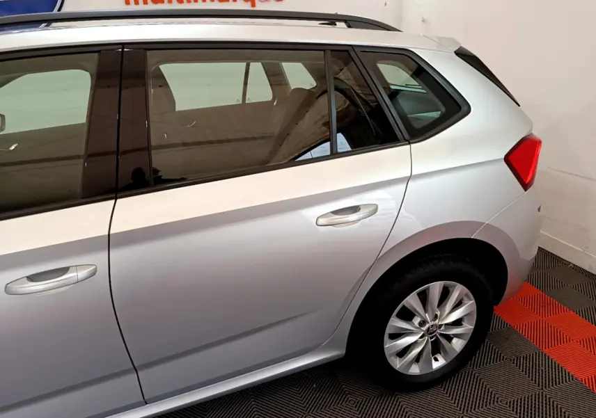 Vue latérale droite du Skoda Kamiq gris clair 2022, mettant en valeur la porte arrière et la roue arrière en jante alliage.