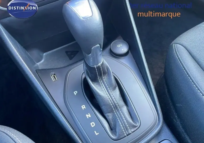 Gros plan sur le levier de vitesses automatique noir dans l'habitacle de la Ford Fiesta blanche, côté siège passager.