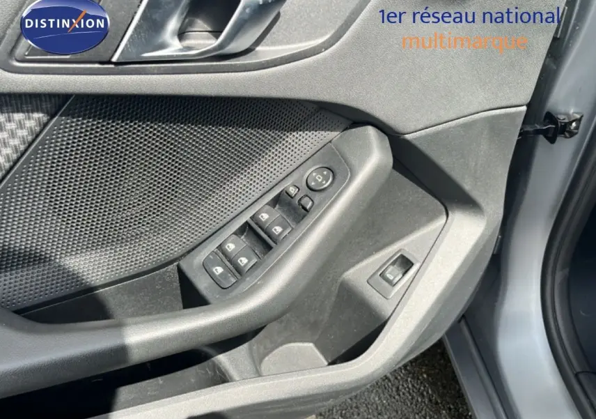 Détail du tableau de bord de la BMW Série 1 116i 2022, bouton des phares en mode automatique, finition gris texturé.