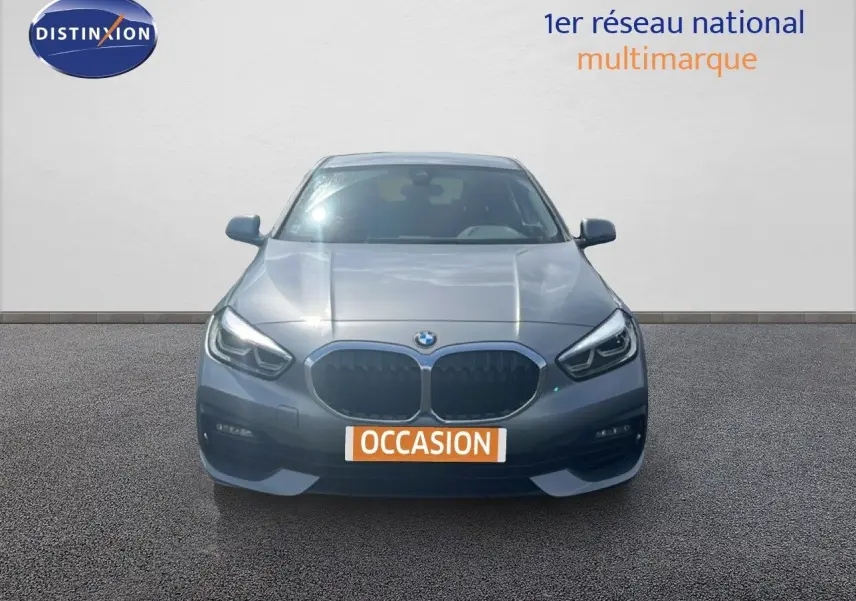 BMW Série 1 116i gris Frozen Pure Grey vue de face, mettant en valeur sa calandre et ses phares LED distinctifs.