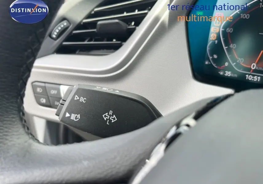 Vue intérieure du tableau de bord de la BMW Série 1 116i 2022 avec écran multimédia affichant la navigation.