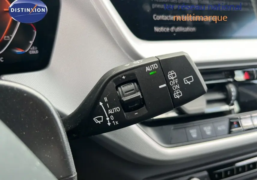 Gros plan sur la console centrale de la BMW Série 1 116i 2022, avec levier de vitesse et commandes multifonctions.