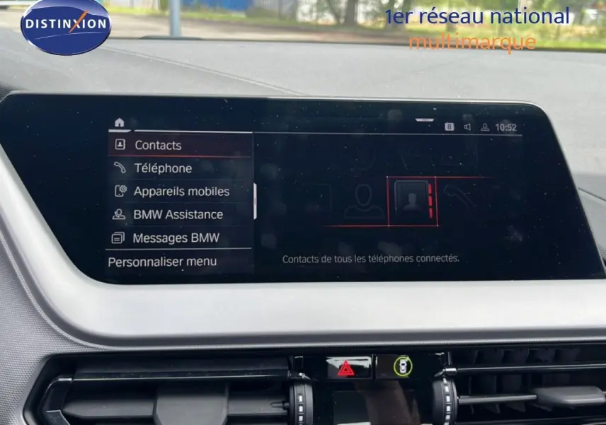 Gros plan sur le volant cuir noir de la BMW Série 1 116i 2022, montrant les commandes de régulateur de vitesse à gauche.