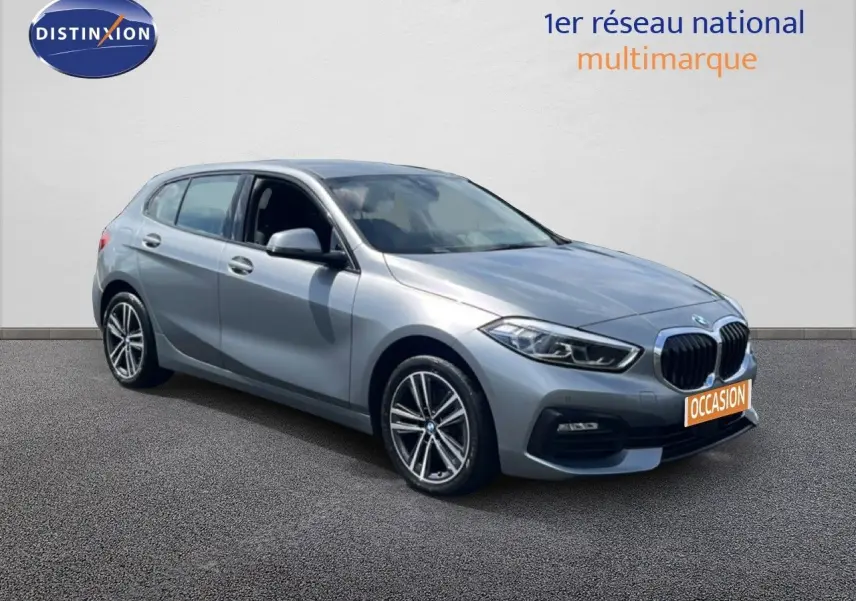 BMW Série 1 116i gris Frozen Pure Grey vue 3/4 avant droit, avec jantes alliage et calandre distinctive.
