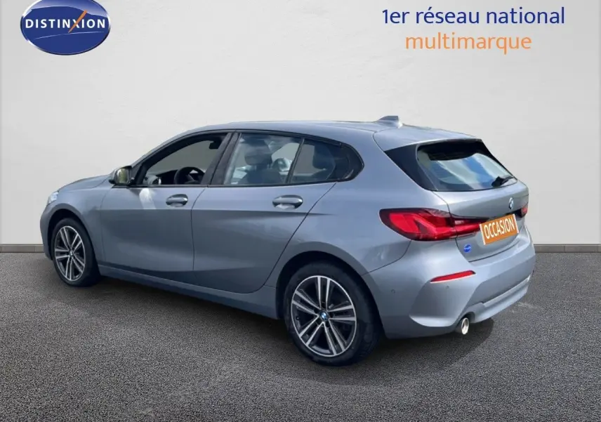 BMW Série 1 116i 2022 en Frozen Pure Grey vue 3/4 arrière droit, avec jantes alliage et feux LED distinctifs.