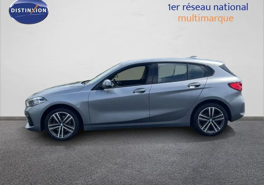 Profil droit d'une BMW Série 1 116i 2022 en gris mat Frozen Pure Grey avec jantes alliage bi-ton et vitres teintées.