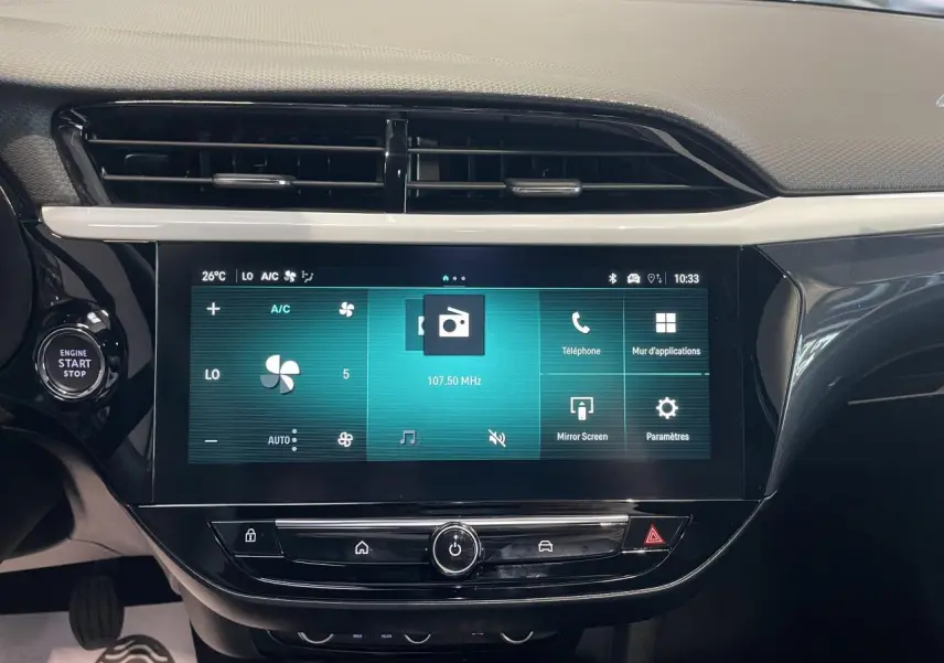 Vue rapprochée de la console centrale avec écran tactile 10 pouces et bouton Start/Stop sur Opel Corsa rouge.