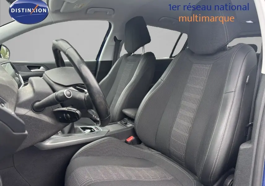 Vue intérieure des sièges avant en tissu noir et tableau de bord partiel d'une Peugeot 308 Bleu Magnetic de 2020.