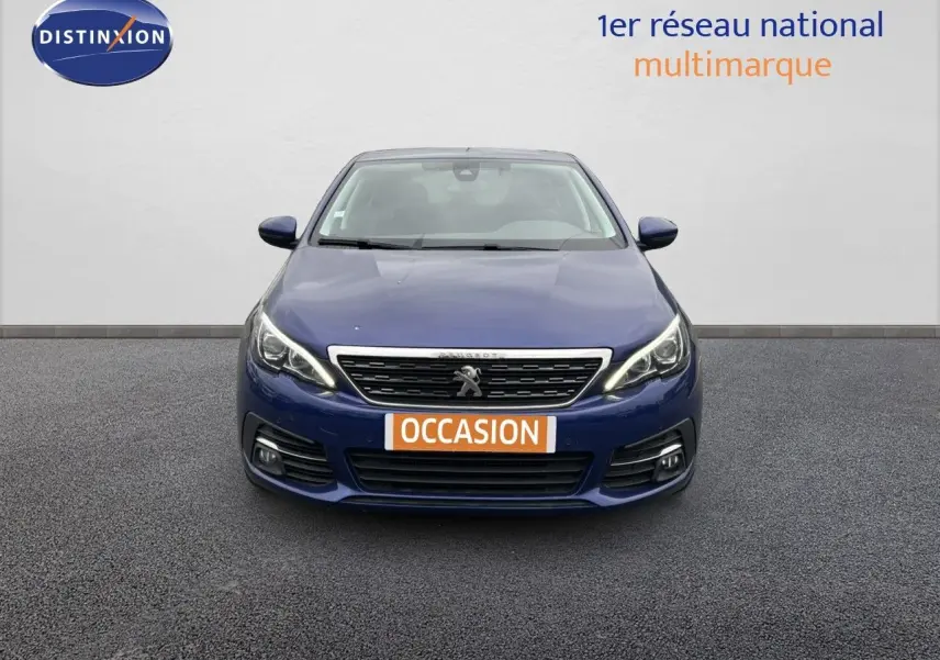 Vue frontale d'une Peugeot 308 Bleu Magnetic de 2020 avec phares LED et plaque "OCCASION" visible.