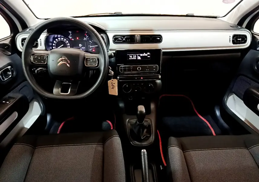 Vue intérieure avant de la Citroën C3 blanche 2018, tableau de bord moderne avec volant multifonction et boîte manuelle.