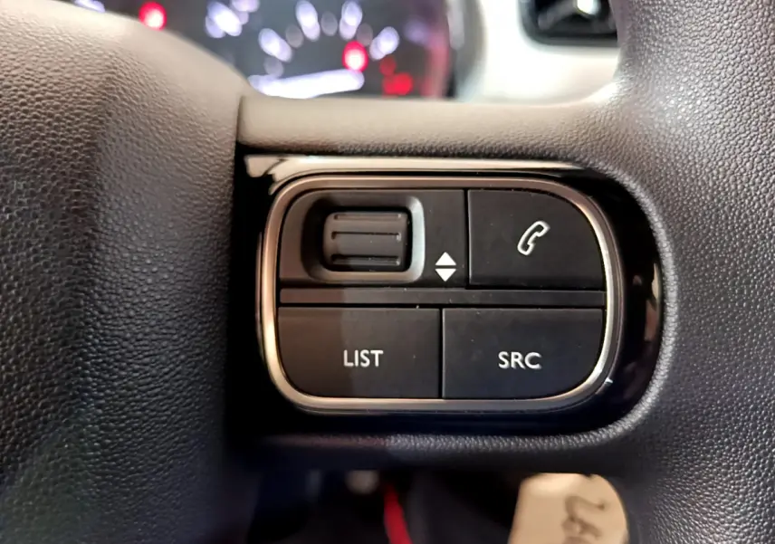 Gros plan sur les commandes multifonctions noires du volant de la Citroën C3 PureTech 68 BVM Live 2018.