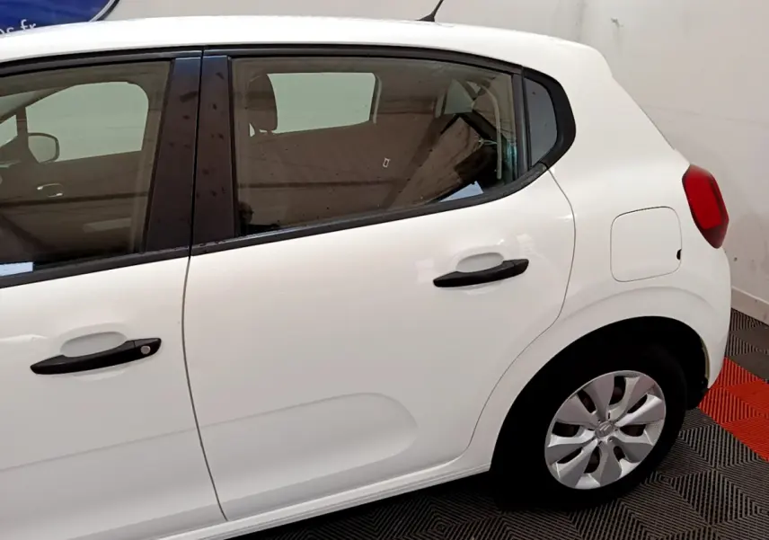 Vue latérale droite d'une Citroën C3 blanche de 2018, mettant en valeur les poignées noires et les jantes compactes.
