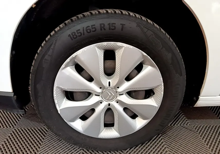 Gros plan sur la roue avant droite d'une Citroën C3 blanche avec jante argentée et logo Citroën central.