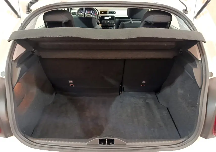 Coffre ouvert vu de l'arrière d'une Citroën C3 blanche, montrant l'espace de chargement et l'intérieur noir.