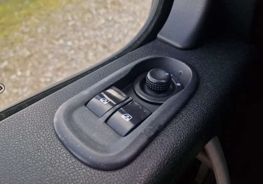 Gros plan sur les commandes électriques des vitres et rétroviseurs côté conducteur du Renault Master Plancher Cabine blanc.