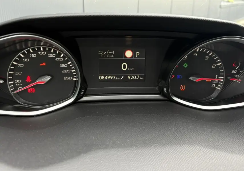 Tableau de bord de Peugeot 308 blanc nacré 2019 avec compteur digital et voyants allumés au ralenti