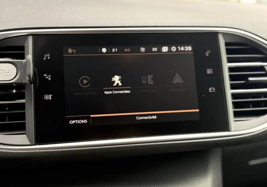 Écran tactile central affichant les options de connectivité dans l'habitacle d'une Peugeot 308 blanche de 2019