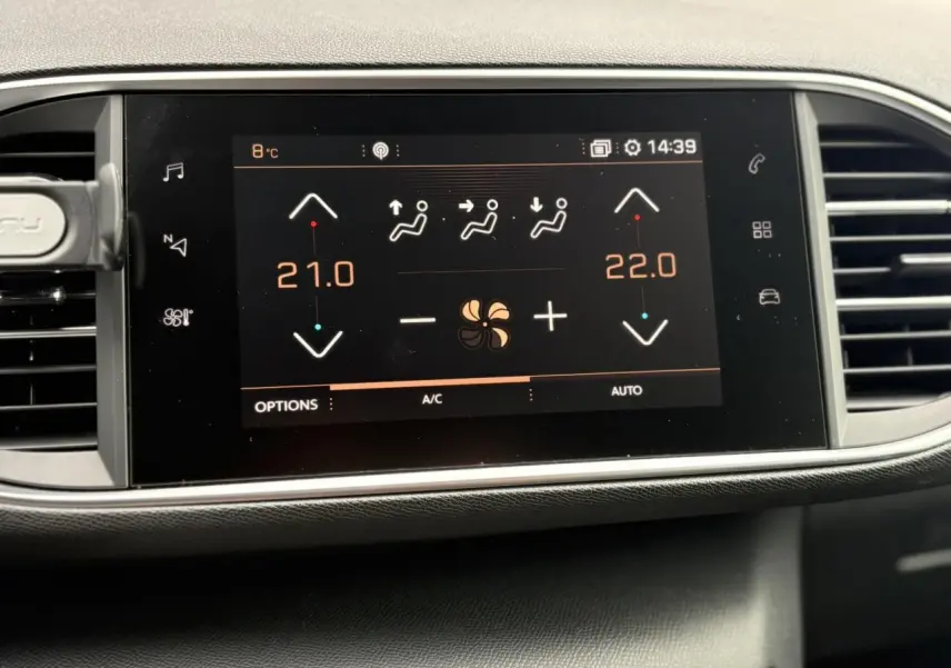 Écran tactile du tableau de bord de la Peugeot 308 blanc nacré affichant la climatisation bi-zone