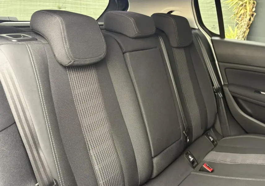 Vue intérieure des sièges arrière noirs de la Peugeot 308 1.2 PureTech 130 Allure avec appuie-têtes et ceintures visibles.