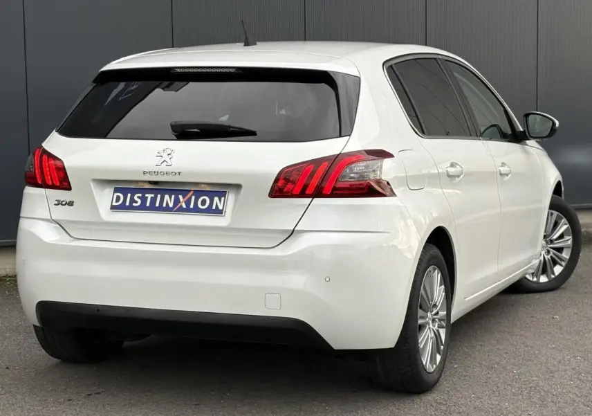 Vue 3/4 arrière droite d'une Peugeot 308 blanc nacré avec feux arrière LED et vitres surteintées