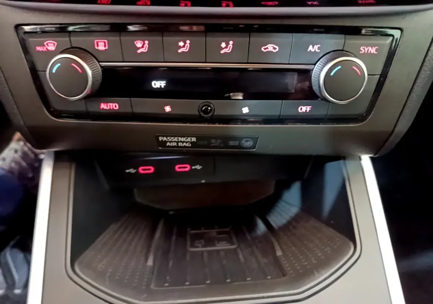 Vue rapprochée de la console centrale du SEAT Arona 2022, avec commandes climatisation et zone de recharge noire.