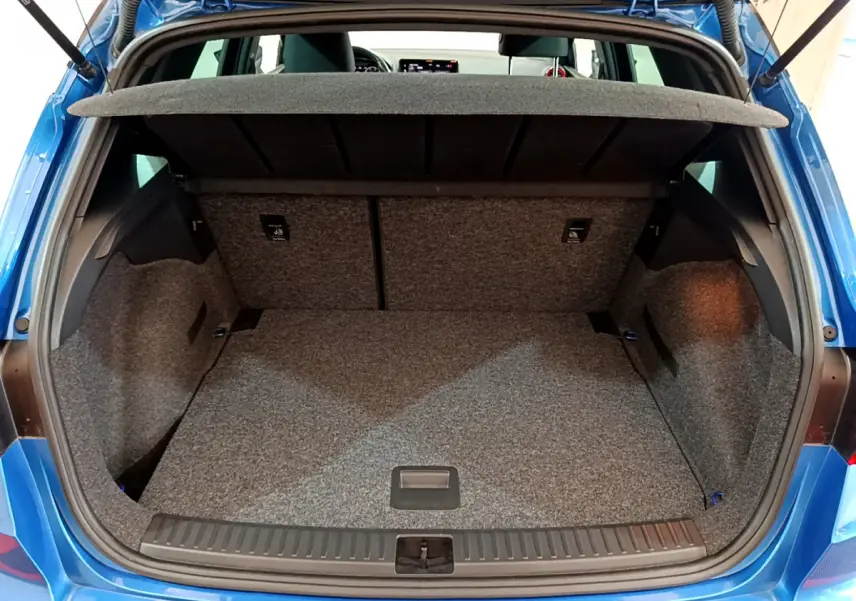 Coffre ouvert vu de l'arrière d'un SEAT Arona bleu 2022, espace de rangement avec tablette amovible.
