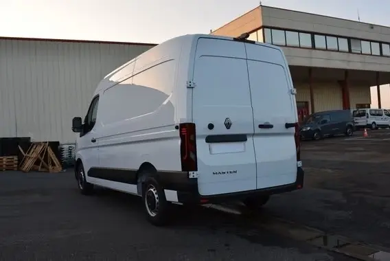 Vue 3/4 arrière droite d’un Renault Master blanc 2025 avec portes arrière fermées et feux LED distinctifs.
