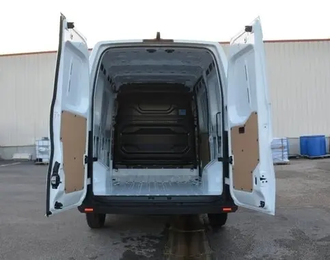 Vue arrière du Renault Master blanc 2025 avec portes arrière ouvertes montrant l'espace de chargement vide et la cloison pleine.