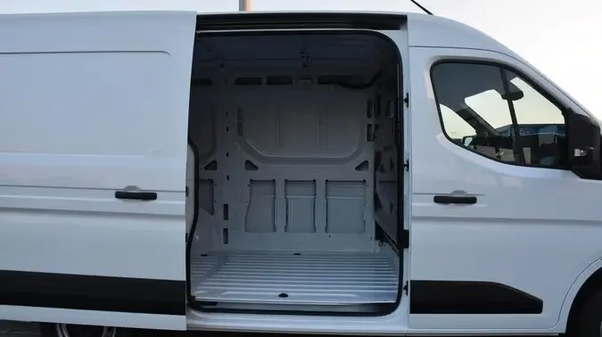 Vue latérale droite d’un Renault Master blanc 2025 avec porte coulissante ouverte montrant l’espace de chargement vide.