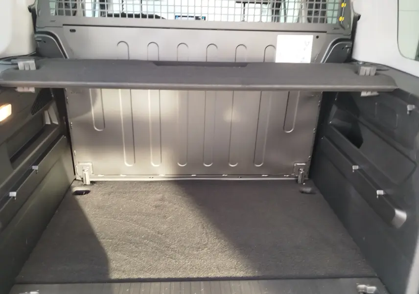 Vue intérieure du coffre du Citroën Berlingo gris acier 2026, montrant la séparation métallique et le plancher plat.