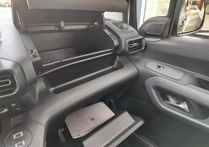 Intérieur du Citroën Berlingo 2026 gris acier, vue côté passager sur les deux boîtes à gants ouvertes et la portière.