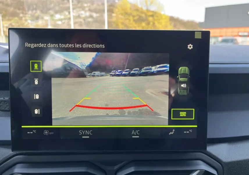 Écran tactile intérieur montrant la caméra multiview arrière du Dacia Bigster gris schiste en stationnement.