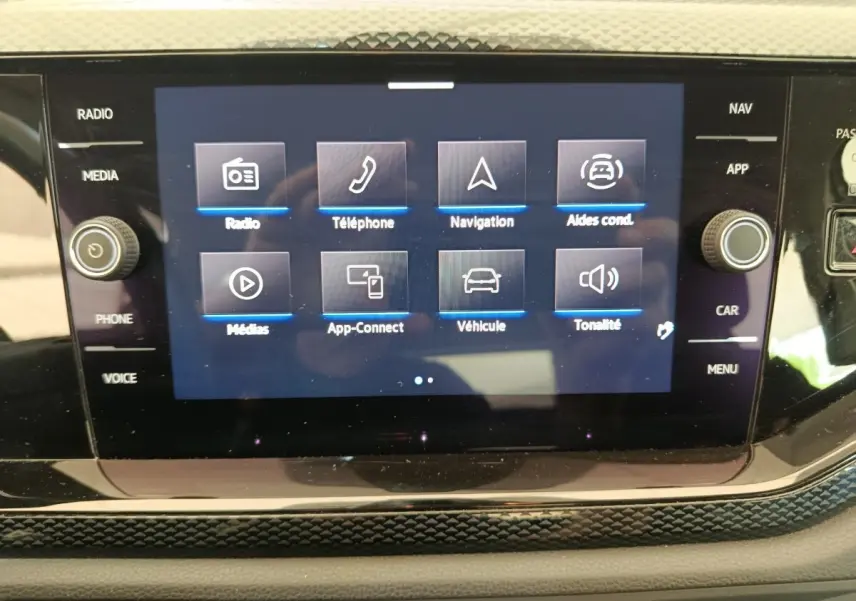 Écran tactile central du tableau de bord de la Volkswagen Polo gris clair, affichant le menu multimédia et navigation.