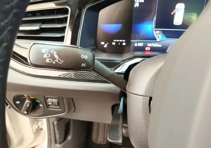 Détail intérieur du tableau de bord côté gauche de la Volkswagen Polo 2023 avec commandes de phares et levier de clignotant.