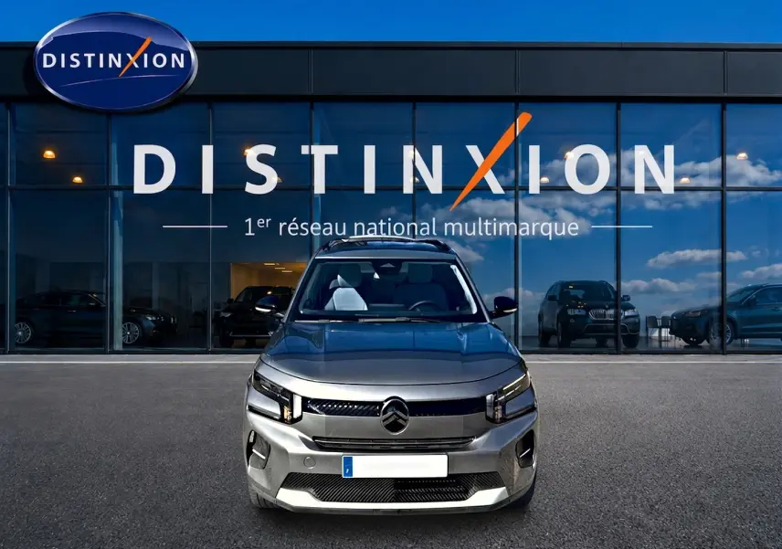 Vue frontale d'une Citroën C3 gris mercure 2025, avec phares LED et calandre moderne, devant un showroom Distinxion.