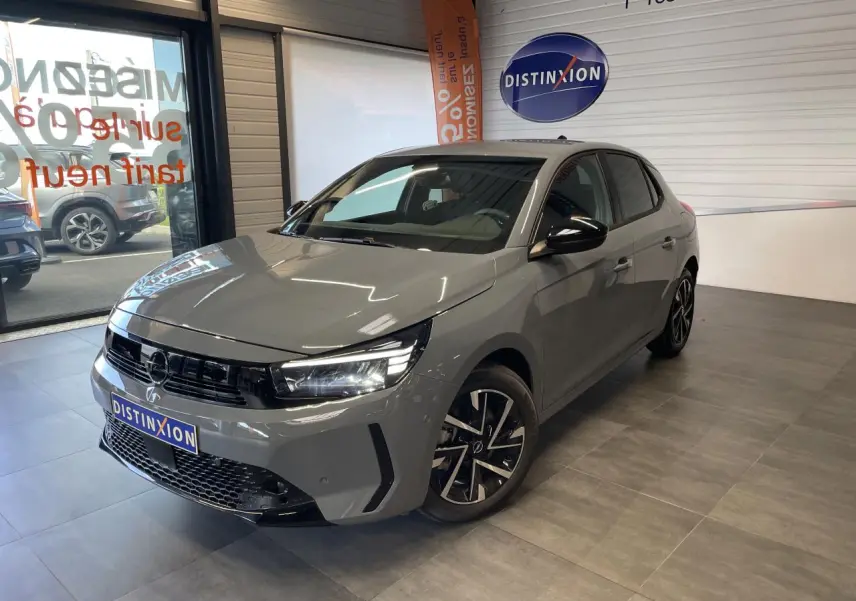 Opel Corsa gris Grafik vue 3/4 avant droit en intérieur avec calandre noire et jantes alliage 16 pouces.