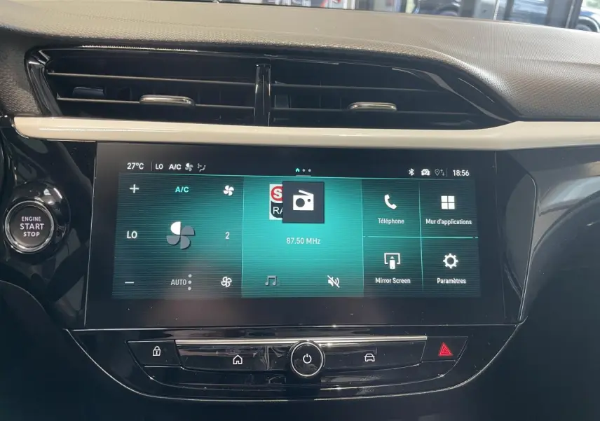 Vue rapprochée de l'écran tactile 10 pouces et du bouton start/stop dans l'habitacle noir de l'Opel Corsa gris.