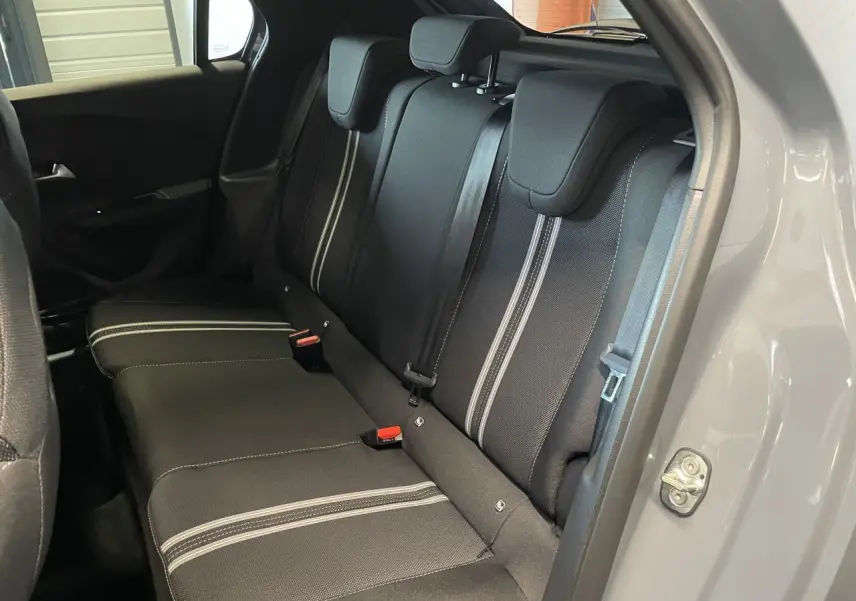 Vue côté droit de la banquette arrière noire avec surpiqûres blanches dans une Opel Corsa gris clair 2026.