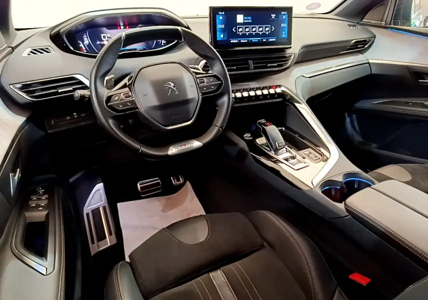 Vue intérieure avant du Peugeot 5008 GT Pack 2021, volant compact, écran tactile central et sellerie noire élégante.