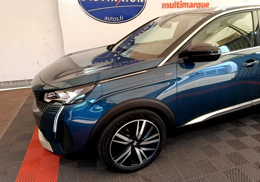 Vue 3/4 avant gauche d'un Peugeot 5008 GT Pack bleu avec jantes alliage et signature lumineuse LED verticale distinctive