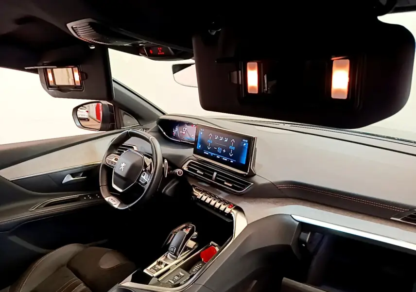 Intérieur Peugeot 5008 GT Pack 2021 vu côté conducteur, tableau de bord moderne avec écran tactile et éclairage ambiant.