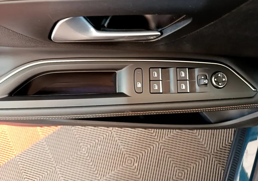 Vue rapprochée de la porte côté conducteur du Peugeot 5008 bleu, avec commandes des vitres et rétroviseurs intégrées.