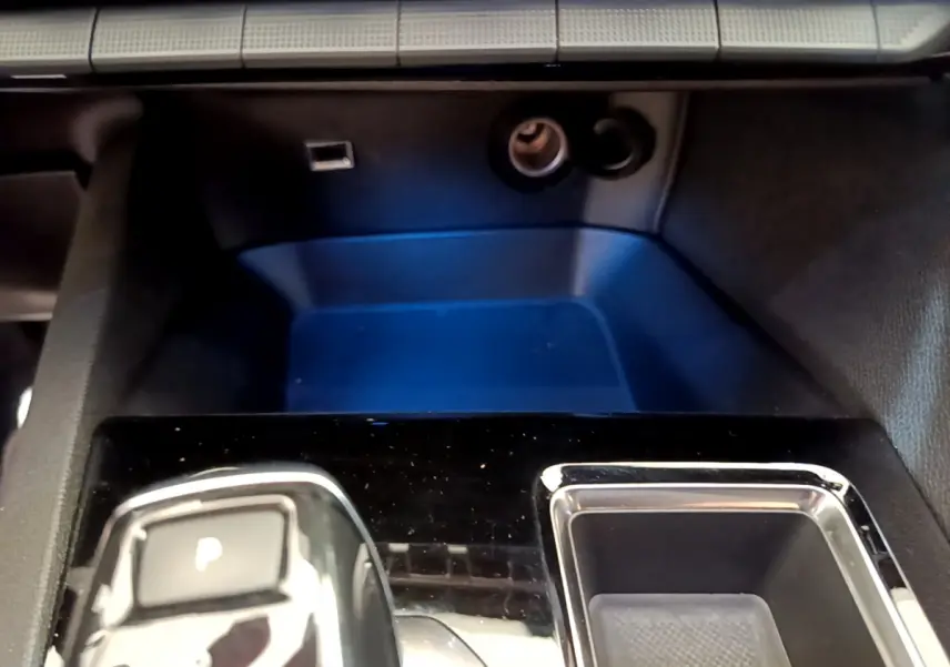 Gros plan sur la console centrale noire brillante du Peugeot 5008 GT Pack 2021 avec bouton de frein à main électrique.