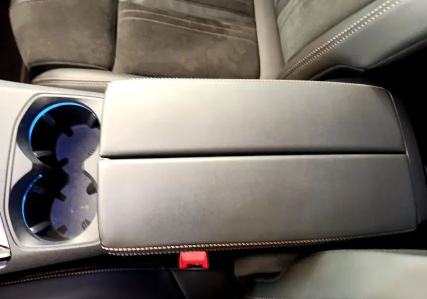 Gros plan sur l'accoudoir central noir et porte-gobelets éclairé à l'intérieur du Peugeot 5008 GT Pack 2021.