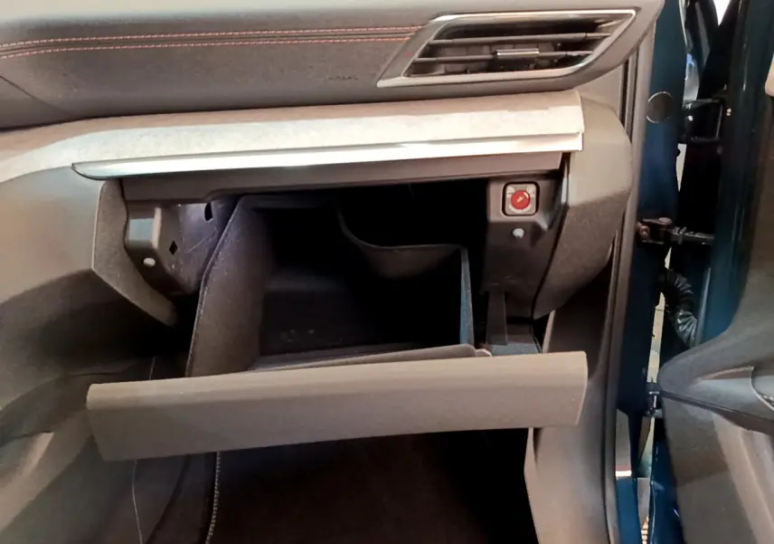 Vue intérieure côté passager du Peugeot 5008 bleu 2021, avec boîte à gants ouverte et tableau de bord gris anthracite.