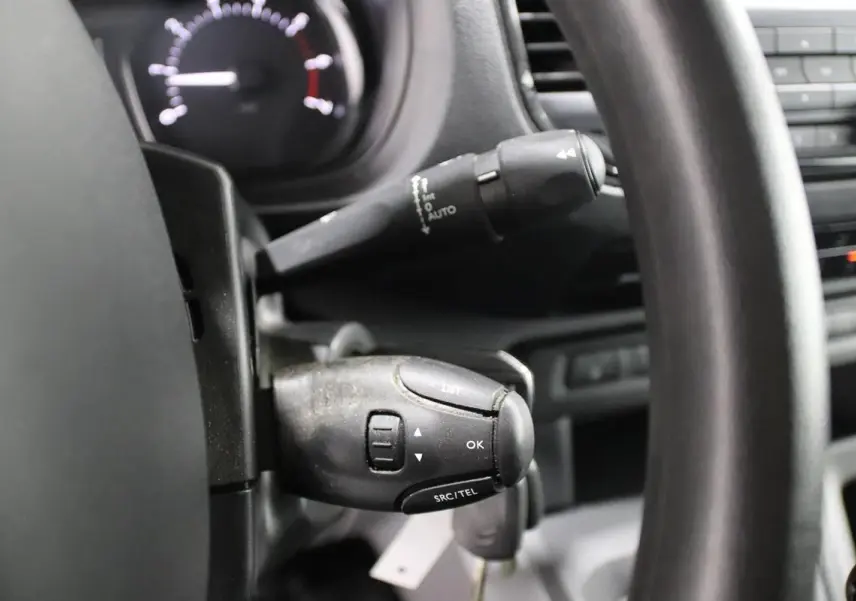 Gros plan sur la commande au volant du Citroën Jumpy Fourgon XL blanc, mettant en valeur les boutons de contrôle audio et téléphone.