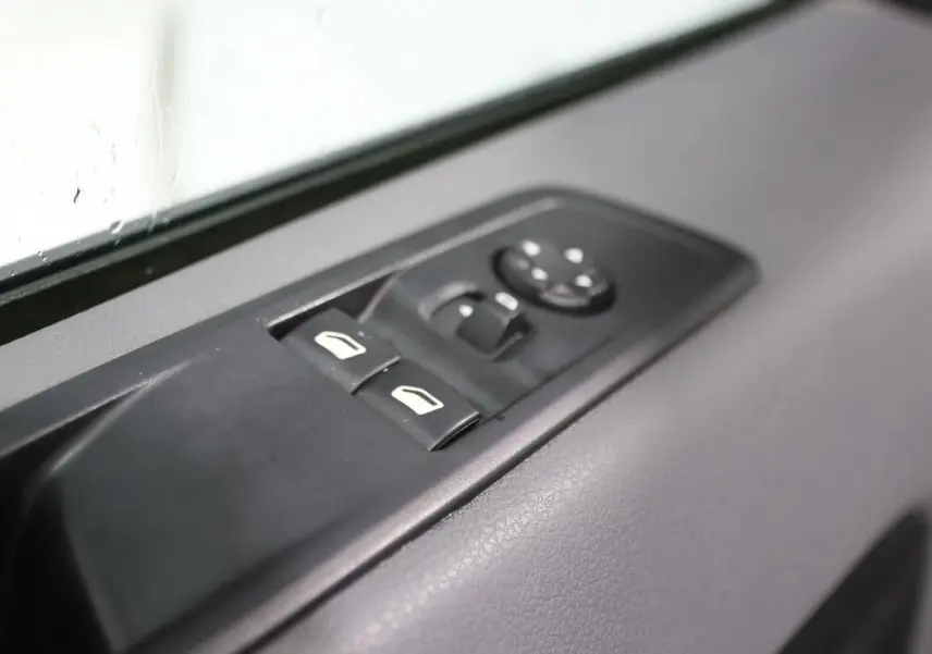 Gros plan sur les commandes de lève-vitres et rétroviseurs côté conducteur du Citroën Jumpy Fourgon XL blanc 2019.