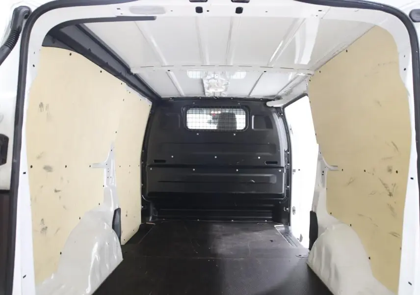 Intérieur du fourgon blanc Citroën Jumpy XL 2019, vue de la zone de chargement avec habillage bois et cloison métallique noire.